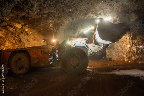 Underground gold bauxite mine shaft tunnel with LHD machine scoop photo