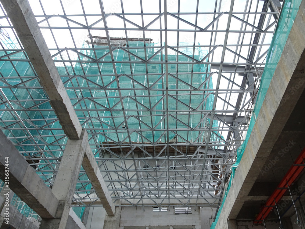 Obraz premium KUALA LUMPUR, MALAYSIA -JUNE 16, 2019: Lightweight roof trusses under construction at the construction site. Installed properly by workers to received the roof covering system.