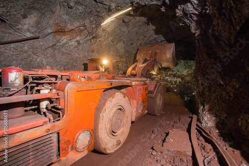 Underground gold bauxite mine shaft tunnel with LHD machine scoop photo