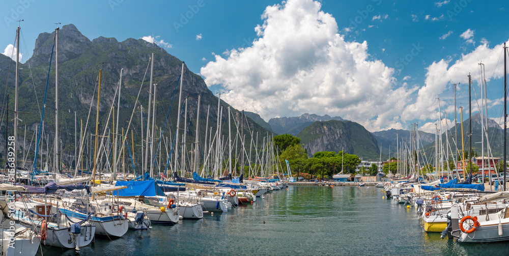 RIVA DEL GARDA, ITALY - JUNE 8, 2019: Riva del Garda - The yachts in harbor with the Alps in the backgound.