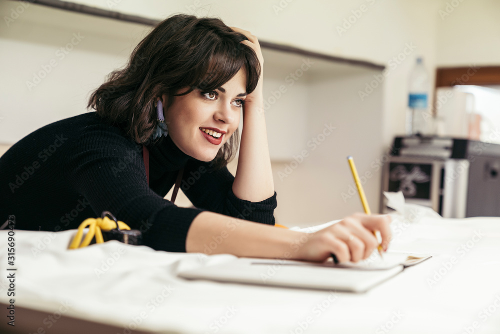 Portrait of young fashion designer leaning on desk Portrait of young fashion designer leaning on desk