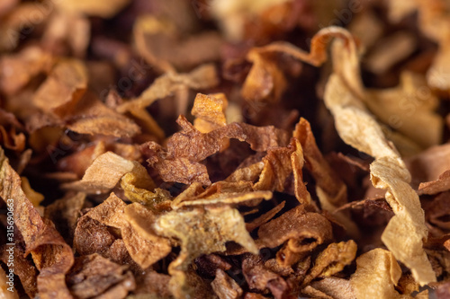 A pile of freshly cut tobacco texture in the background. Closeup