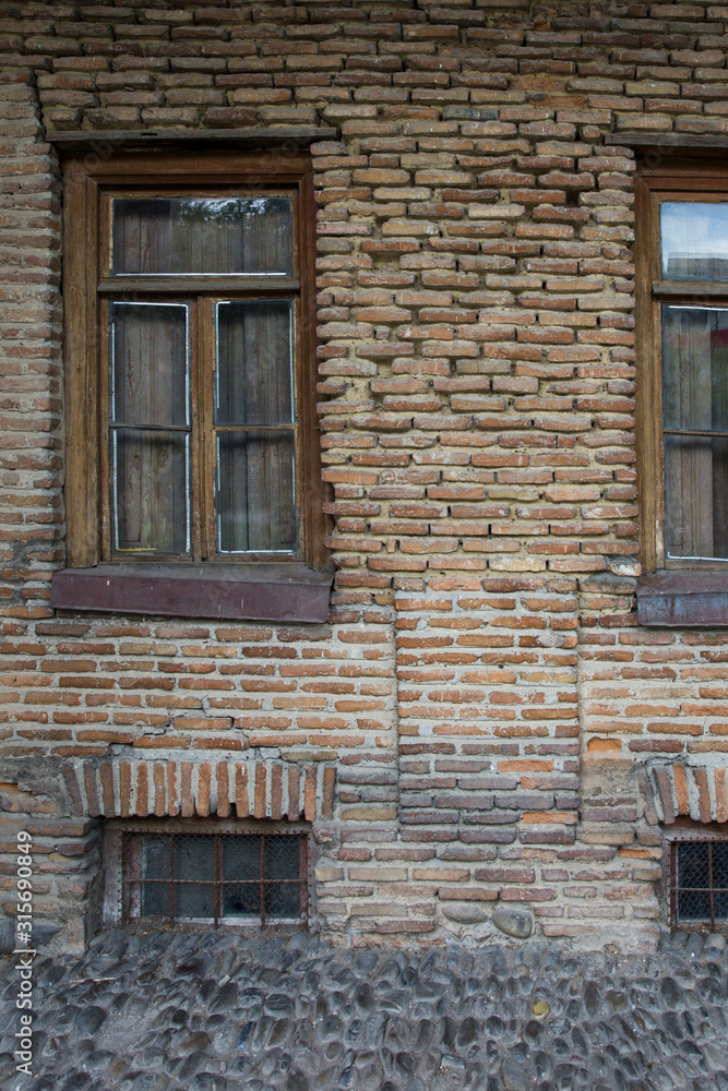 An old brick house with wooden windows An old brick house with wooden windows