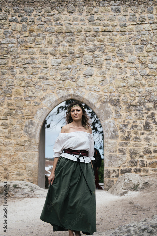 Portrait of woman wearing medieval European maidservant clothes on outdoors. Festival in Óbidos Portugal