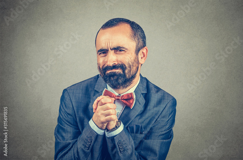 man showing clasped hands, pretty please isolated on gray background. Human emotion facial expression feelings, body language photo