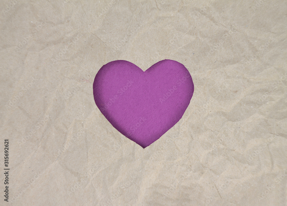 Fototapeta premium Violet felt heart on craft paper. Crumpled paper texture. Valentine's day stock photo for web, print and wallpaper.With empty space for text.