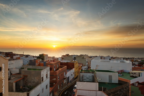 Dawn on Tenerife Island in a small town, colorful houses, sun rising over Gran Canaria © Andrii Marushchynets