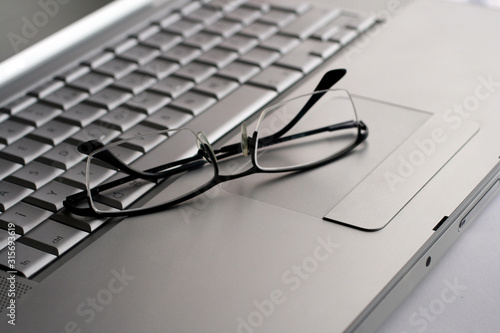 Eyeglasses on a silver keyboard