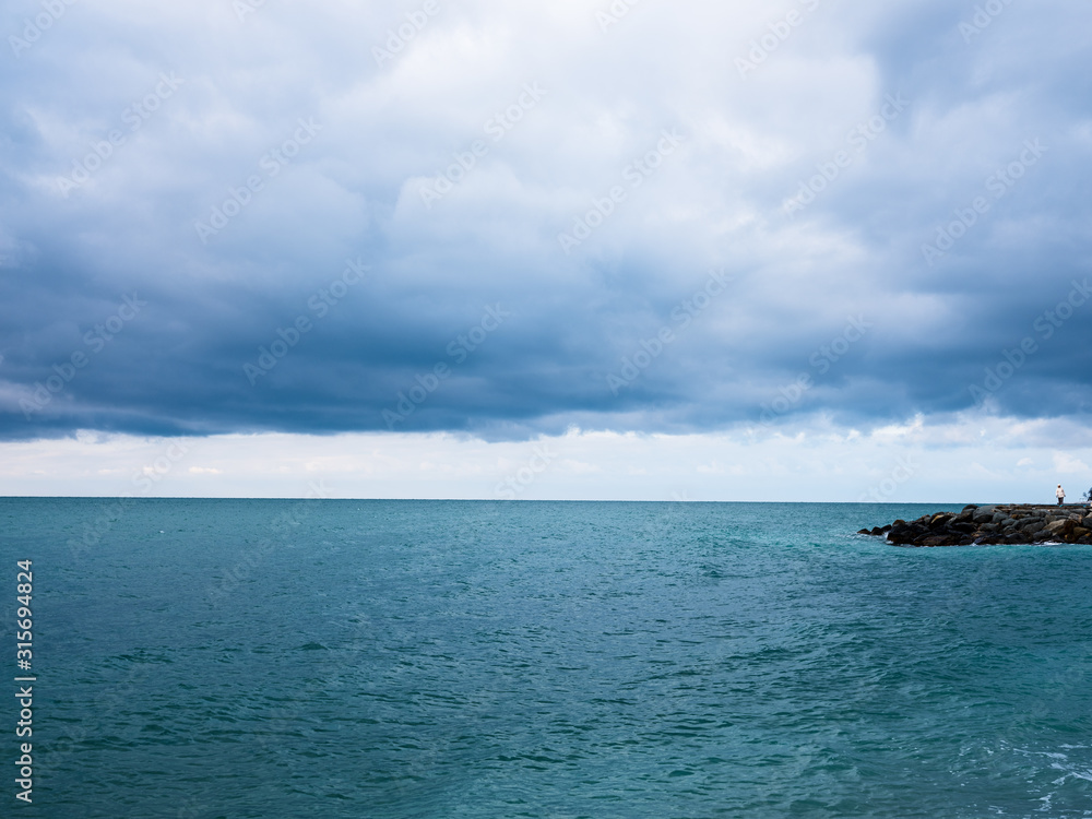 blue sea and cloudy sky over it