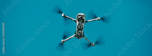Flying drone in army camouflage skin. Banner.
