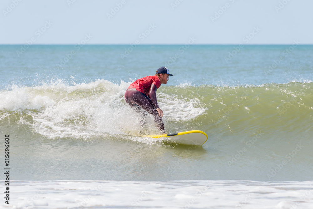 surf instructor decides to join his advanced class in the water. Surf instructor in action surf instructor decides to join his advanced class in the water. Surf instructor in action