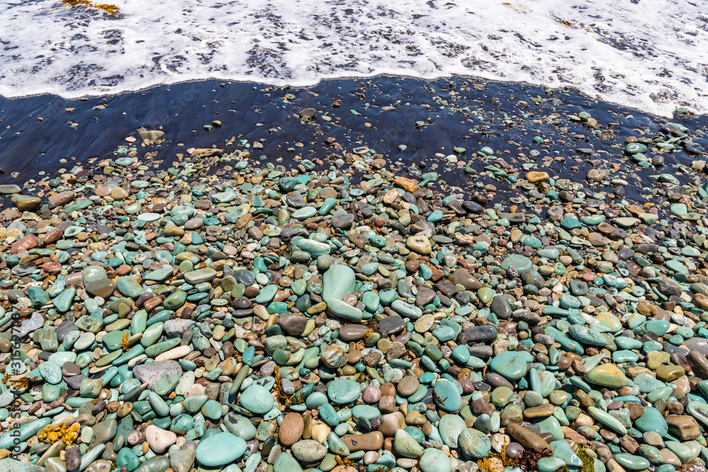Blue Stones beach with black sand and ocean foam near Ende town, Flores Island, Indonesia Blue Stones beach with black sand and ocean foam near Ende town, Flores Island, Indonesia