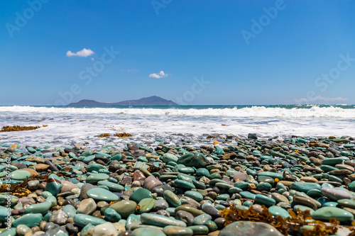 Blue Stones beach with black sand and ocean foam near Ende town, Flores Island, Indonesia