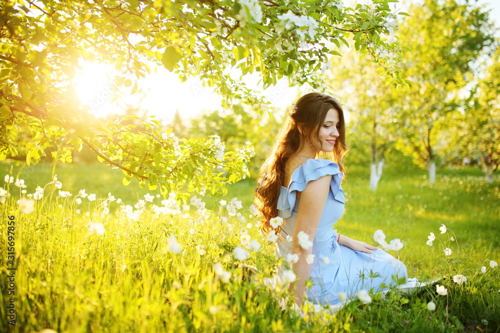 Girl at sunset in a flowering garden Girl at sunset in a flowering garden
