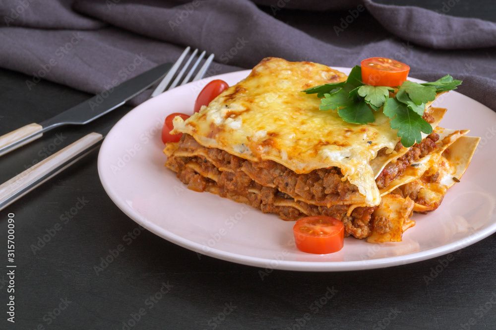 Meat lasagna on a wooden background.