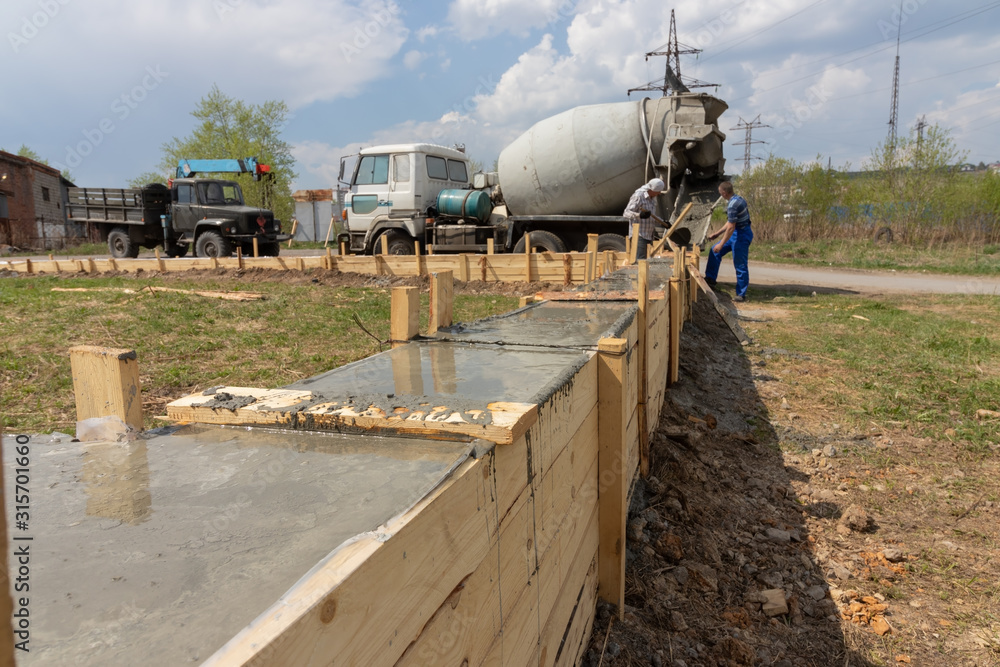 Fill the foundation of the house, garage. The work of construction workers. Fill the foundation of the house, garage. The work of construction workers.