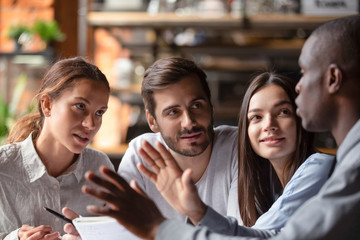 Multiracial young people meeting in cafe studying together