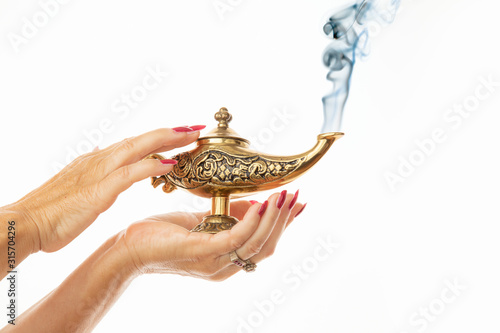 Quadro su tela woman hands wiping a magic lamp on white background