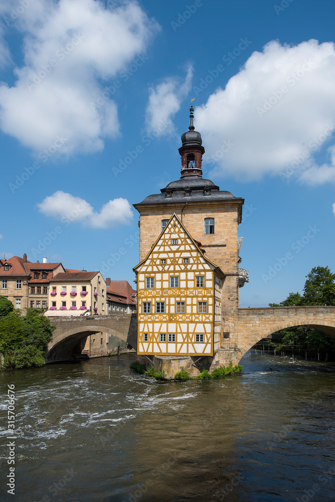 Bamberg, Germany - July 15, 2019; Center of Bamberg a popular tourist destination with ancient center with bridges, flowers and timbered houses in a vertical image