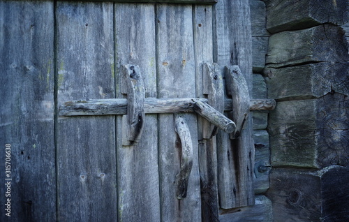 A wooden lock in the door of an old shed