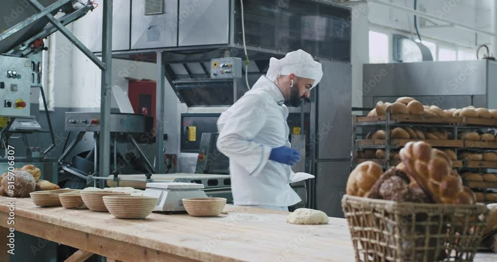Factory food bakery dancing baker in the commercial kitchen listening music from wireless headphones and enjoying the time at work. 4k Factory food bakery dancing baker in the commercial kitchen listening music from wireless headphones and enjoying the time at work. 4k