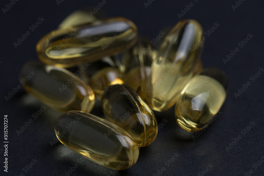 Omega 3 vitamins on a black isolated background close-up. Omega 3 vitamins on a black isolated background close-up.