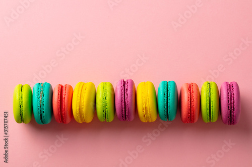 Macaroons dessert on pink background. Copy space. Top view.