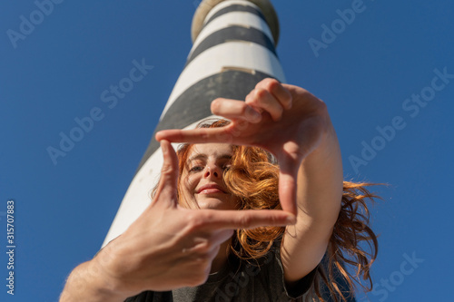 Portrait of redheaded young woman at a lighthouse photo