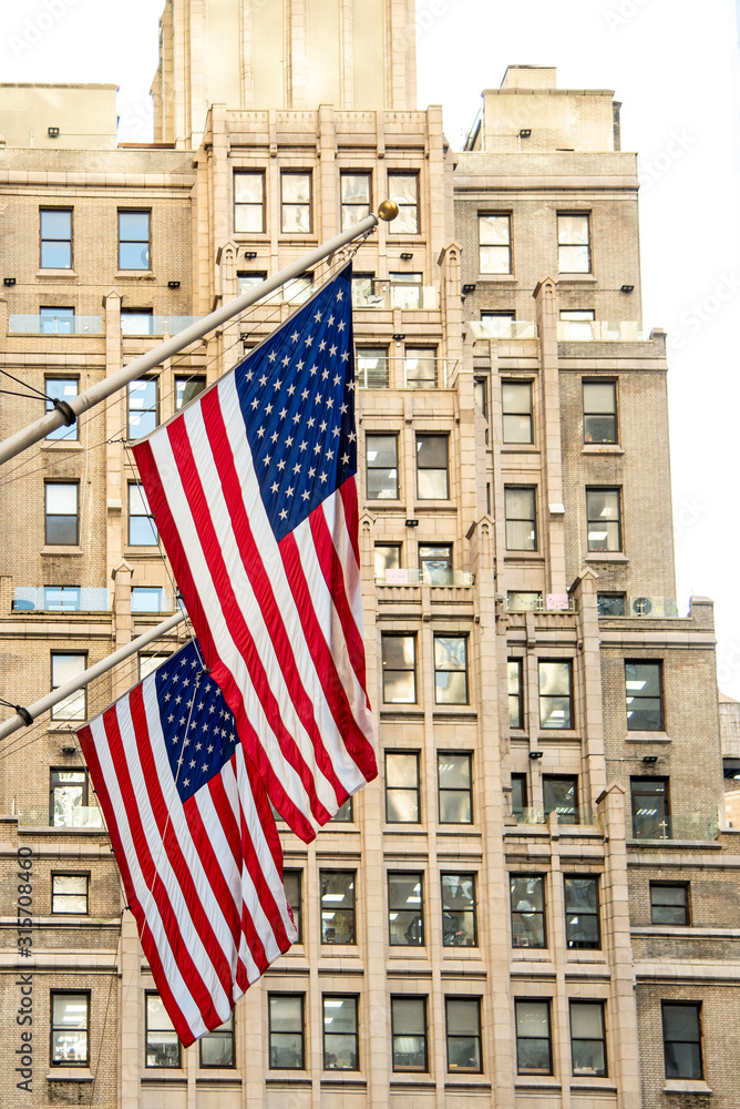 USA, New York, New York City, American flags hanging against skyscraper USA, New York, New York City, American flags hanging against skyscraper