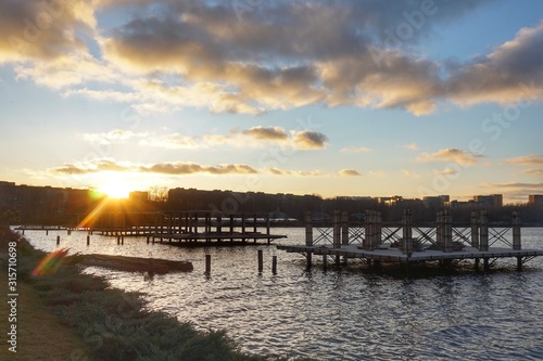 Sunset over the river. Pile moorings are visible from the water. Europe.