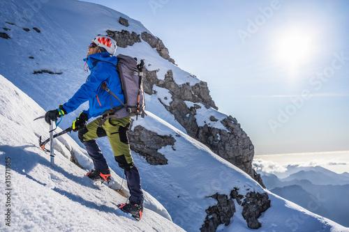 Alpinist ascending a snowy mountain, Orobie Alps, Lecco, Italy