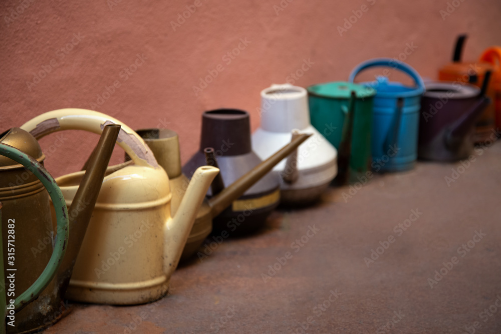 Row of various watering cans for watering flowers Row of various watering cans for watering flowers