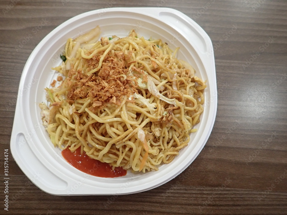 chinese noodles fire with vegetables on a plastic plate chinese noodles fire with vegetables on a plastic plate