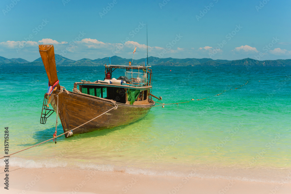 Traditional Thai longtail boat moored on exotic beach. Traditional Thai longtail boat moored on exotic beach.