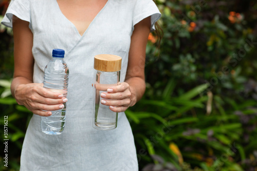 Obraz na płótnie Choosing between plastic bottle and glass bottle. Zero waste concept. Green and conscious lifestyle concept. w salonie