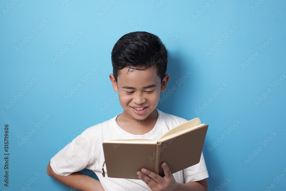 Asian boy smiling happily when reading a book Asian boy smiling happily when reading a book