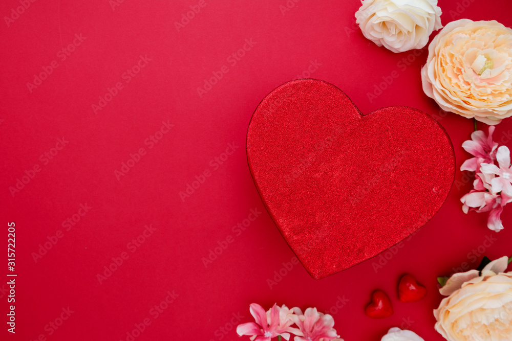 Obraz premium Heart shape gift box with flowers on red backgroun. Valentine's day mock up with copy space.