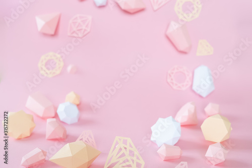 polygonal diamonds made of paper on a pink background © EkaterinaVladimirova