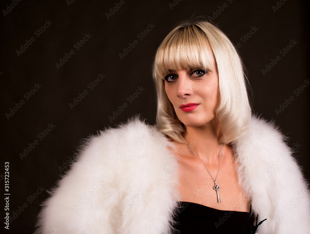 Portrait of a woman with blond hair, wearing a tight dress. On the shoulders of a fur Cape. Portrait of a woman with blond hair, wearing a tight dress. On the shoulders of a fur Cape.
