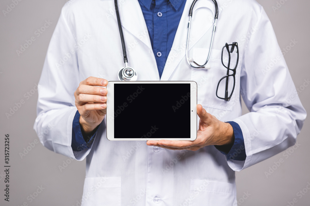 Doctor holding blank digital tablet isolated on grey background with clipping path for the screen. Doctor holding blank digital tablet isolated on grey background with clipping path for the screen.