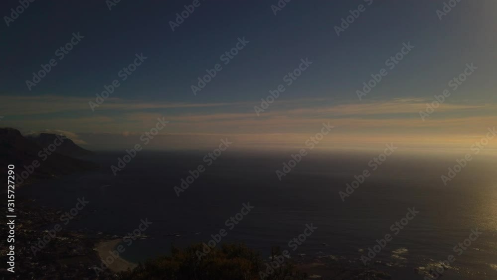 Slow pan of open ocean and mountains as sun sets, from Lion's Head Slow pan of open ocean and mountains as sun sets, from Lion's Head