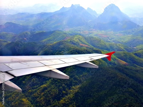Scenery from window looking at Airplane wing with blue sky and clouds. Top view scenery showing city landscape perfect natural river, green forest on mountain at Laos. Travel Transportation concept.