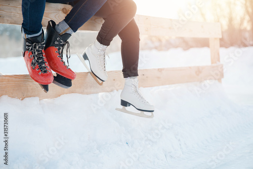 Closeup winter skates on transparent ice rink. Couple in lover © Parilov