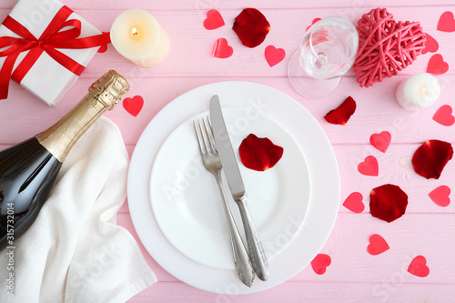 Festive table setting for Valentine's Day with cutlery, gift boxes and hearts on the table. Space for text. View from above.