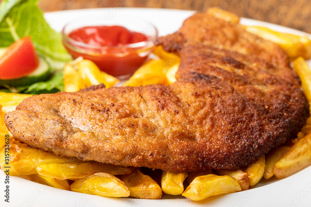 wiener schnitzel with french fries on a plate wiener schnitzel with french fries on a plate
