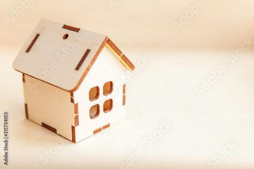 Miniature toy model house on wooden backdrop. Eco Village abstract environmental background. Real estate mortgage property insurance sweet home ecology concept