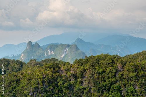 Beautiful view of the rocky hills covered with rainforest in the clouds