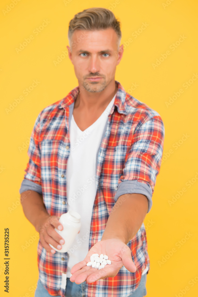 Food additives vitamins male health. Vitamin complex. Handsome man presenting product selective focus. Vitamin pill in hand. Side effects. Medicines concept. CBD concept. Improving quality of life Food additives vitamins male health. Vitamin complex. Handsome man presenting product selective focus. Vitamin pill in hand. Side effects. Medicines concept. CBD concept. Improving quality of life