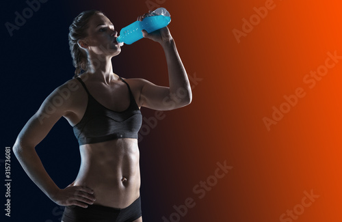 Young girl drinking water of bottle after training. Fitness and healthy lifestyle concept.