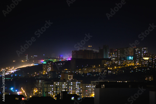Night city skyline. Top aerial panoramic view of modern city from tower rooftop. Road junction traffic